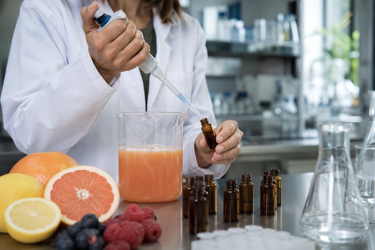 Ученый по пищевым ароматизаторам измеряет прототипы фруктовых пуншей, иллюстрируя контролируемый рабочий процесс разработки вкусов напитков.